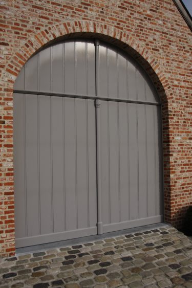 Garagepoort in meranti, voorzien van grondlaag en door klant zelf geschilderd (kantelpoort)