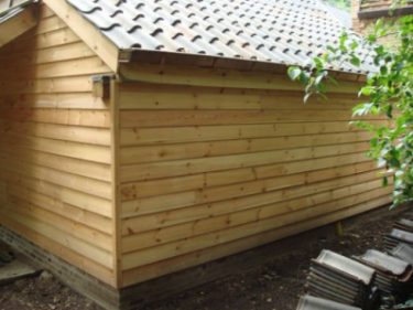 Grenen gevelbekleding aan eikenhouten bijgebouw